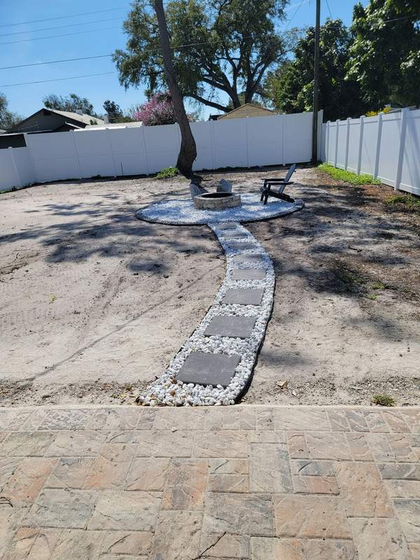 Stone pathway and fire pit area installed in a backyard